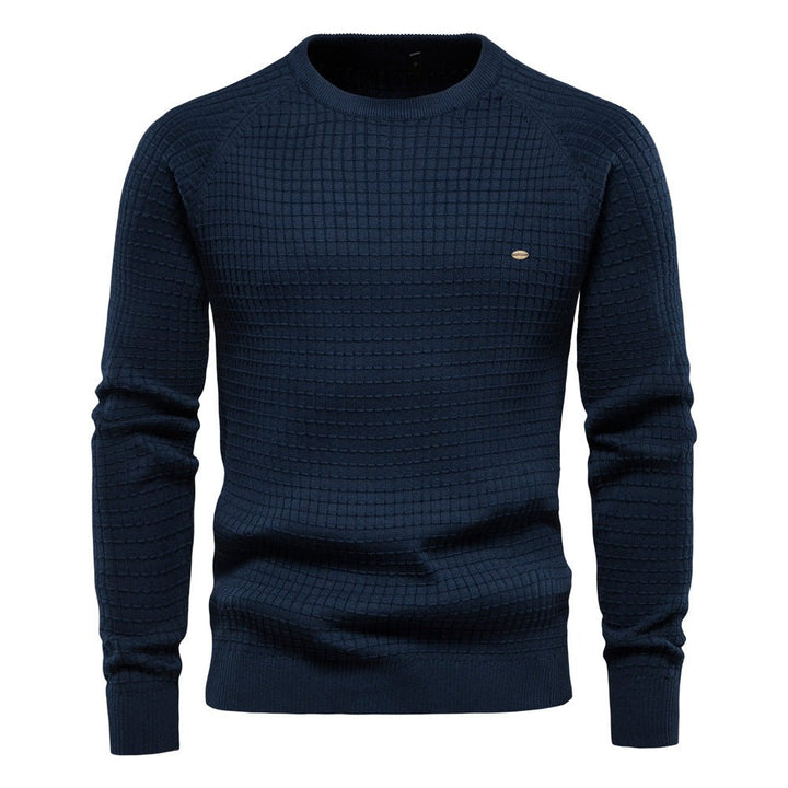 Dunkelblauer Herren-Strickpullover mit Karo-Struktur, Rundhalsausschnitt und Raglanärmeln.