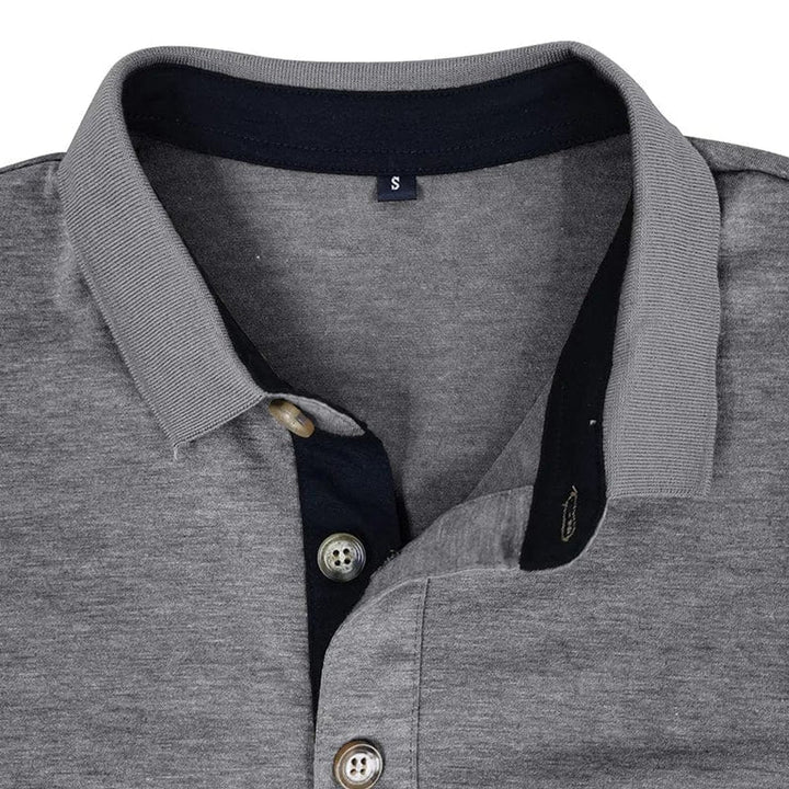 Graues Herren-Langarm-Poloshirt mit kontrastierendem Kragen, Knopfleiste und Brusttasche im Detail.