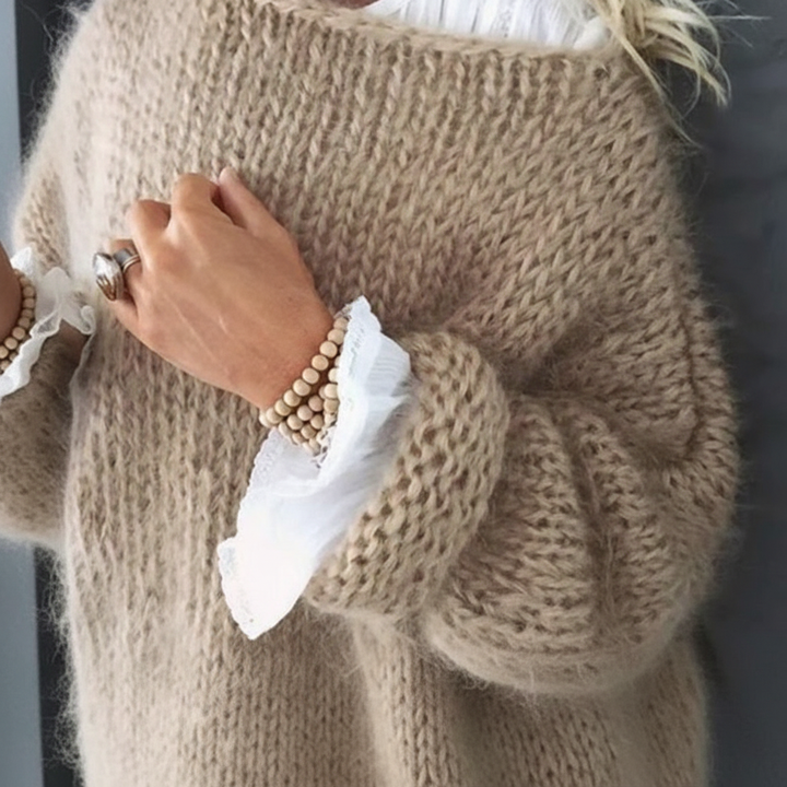 Beiger Oversized-Strickpullover mit flauschigem Grobstrick, weiten Ärmeln und eleganten Umschlag-Bündchen.