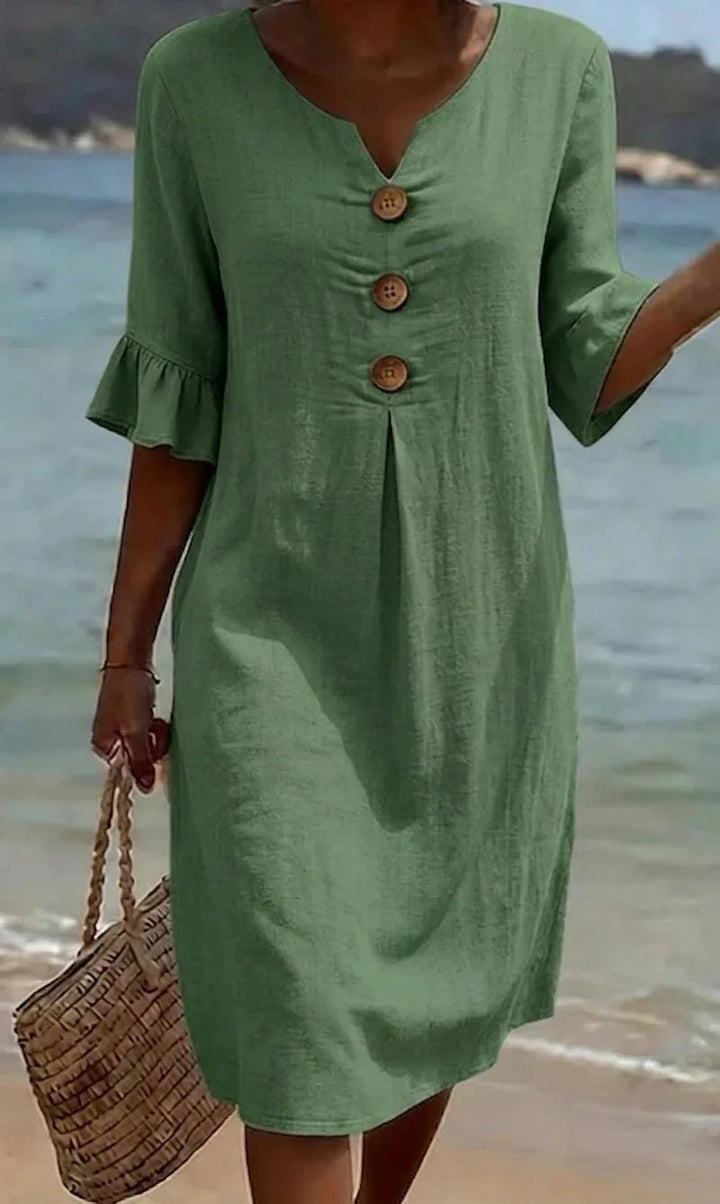 Grünes Fiona Midikleid aus Leinen mit V-Ausschnitt, Volant-Ärmeln und Holzknöpfen am Strand