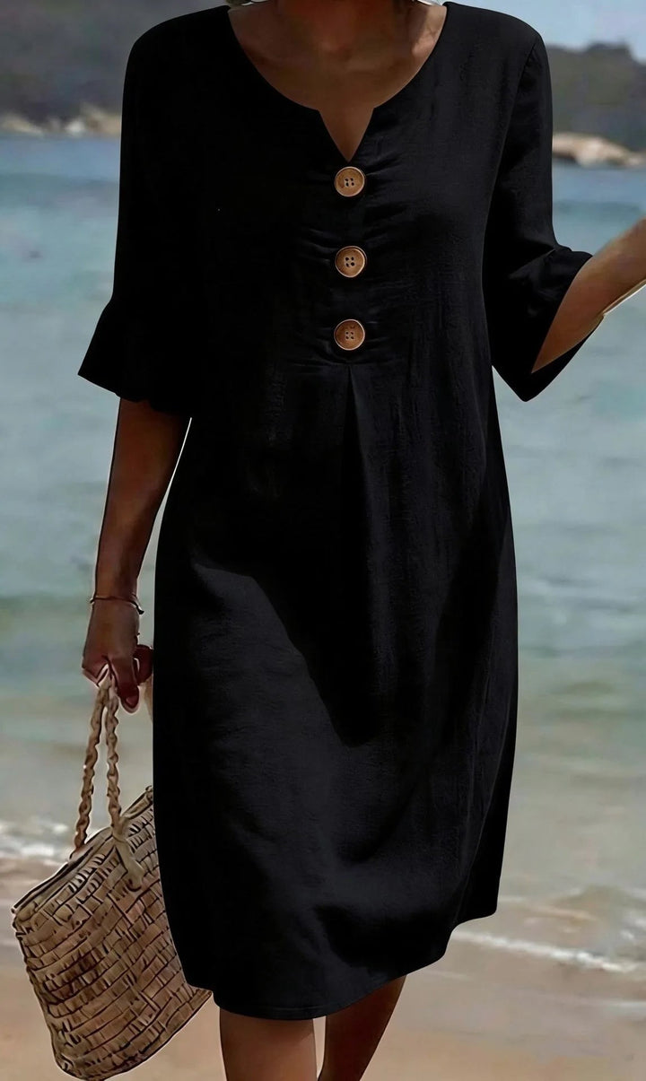 Schwarzes Fiona Midikleid mit V-Ausschnitt, Volant-Ärmeln und Holzknöpfen am Strand