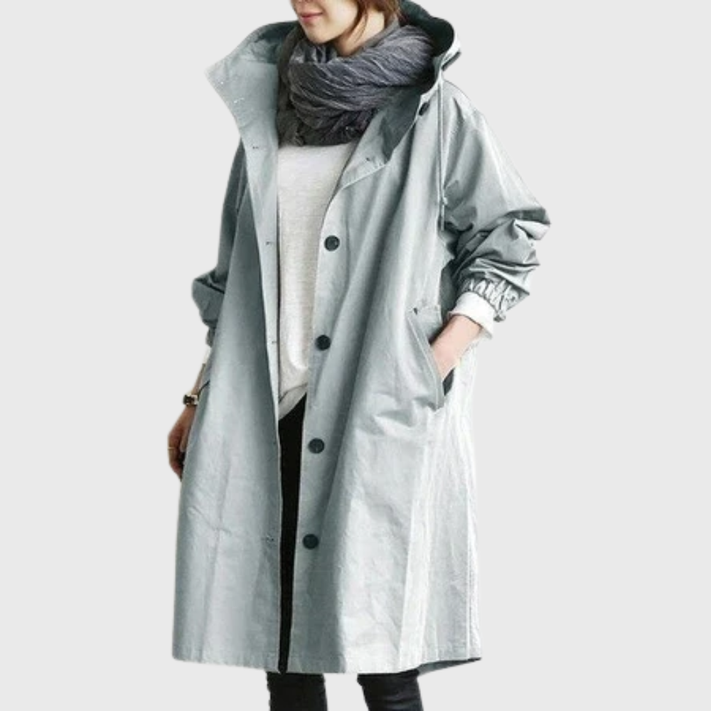 Hellgrauer Damen-Oversized-Mantel mit Kapuze, Knopfleiste und praktischen Seitentaschen für die Übergangszeit.