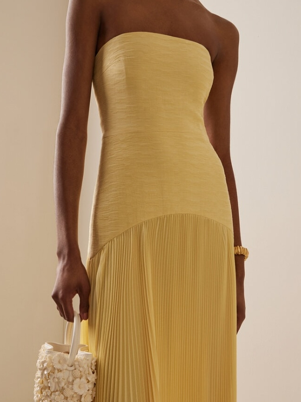 Trägerloses, gelbes Franziska Maxikleid mit plissiertem Rock und tailliertem Oberteil.