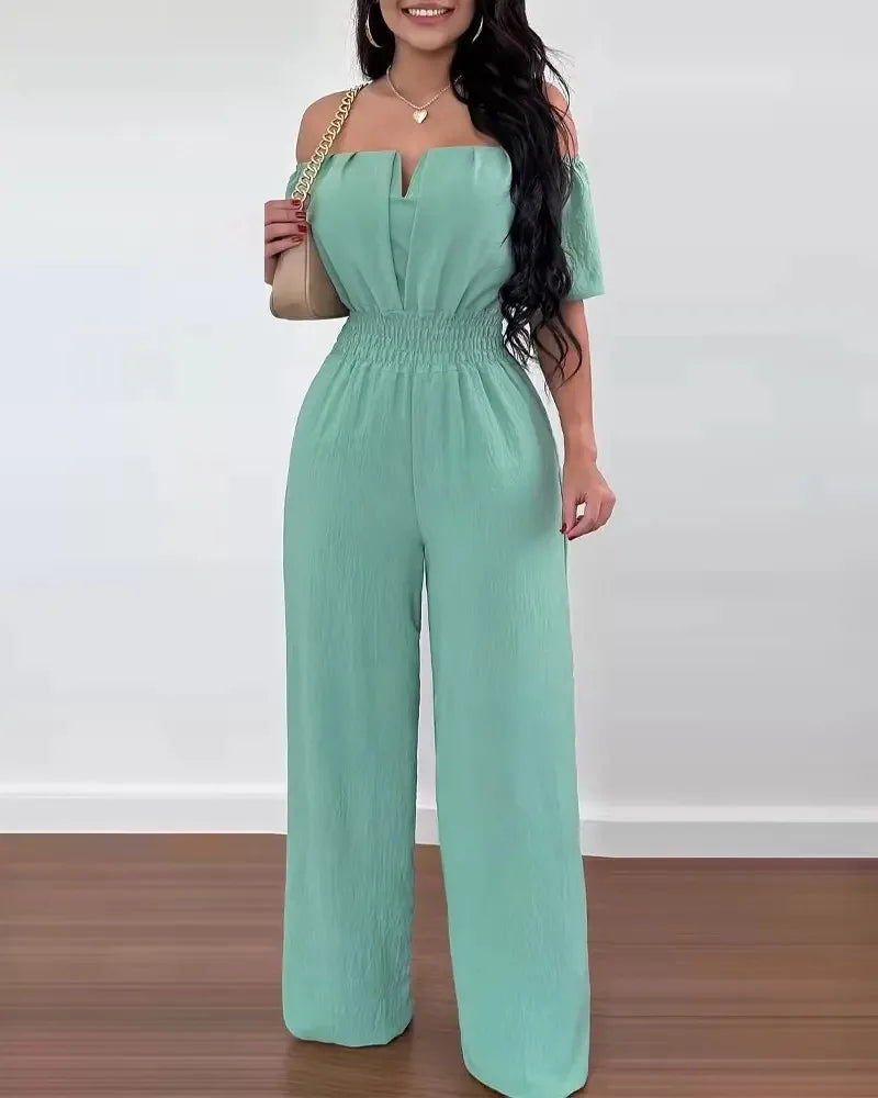Mintgrüner Off-Shoulder Jumpsuit mit weitem Bein, betonter Taille und strukturierter Stoffoptik.
