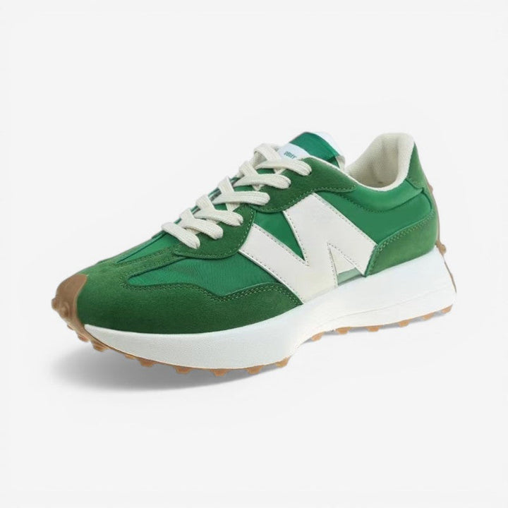 Grüner Retro-Sneaker mit weißem Logo, Wildleder-Details, Mesh-Einsätzen und markanter Gummisohle mit Noppenprofil.