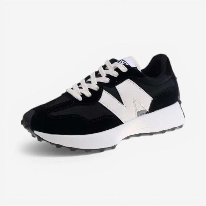 Schwarzer Damen-Retro-Sneaker mit Wildleder-Details, Mesh-Einsätzen, weißem Logo-Element und markanter Gummisohle.