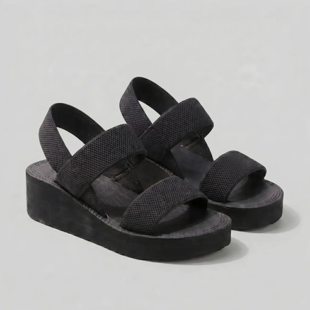 Schwarze Isla Damen Plattform Sandalen mit breiten, strukturierten Riemen und erhöhter Sohle für modernen Komfort.