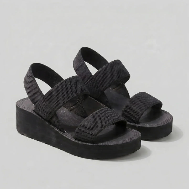 Schwarze Isla Damen Plattform Sandalen mit breiten, strukturierten Riemen und erhöhter Sohle für modernen Komfort.