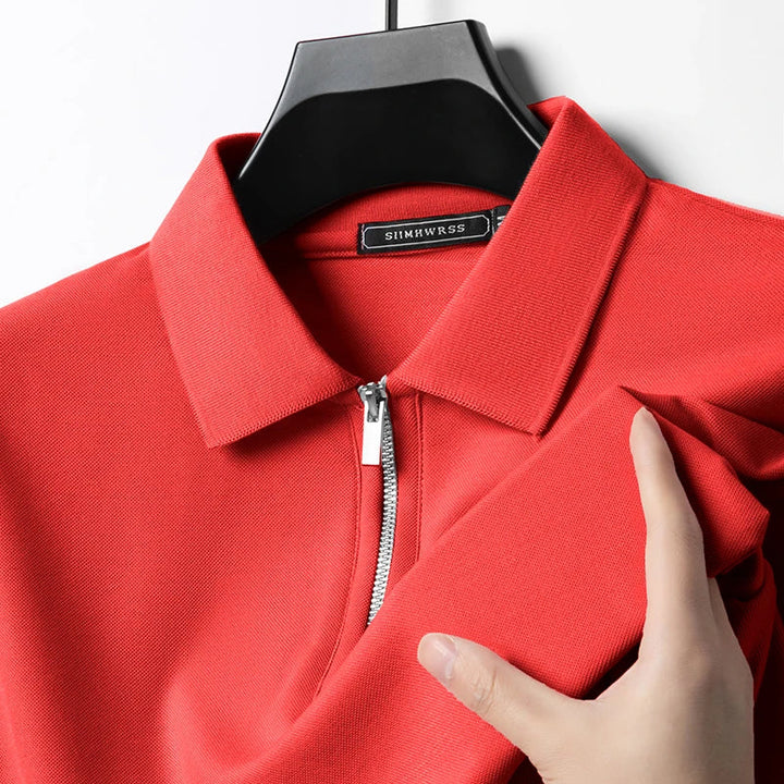 Rotes Herren-Poloshirt mit Reißverschluss, klassischem Kragen und feiner Piqué-Struktur auf einem Kleiderbügel.
