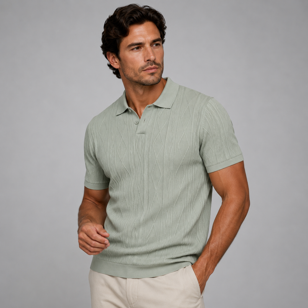 Hellgrünes Herren-Strickpoloshirt mit Rautenmuster, Polokragen und kurzer Knopfleiste auf grauem Hintergrund.