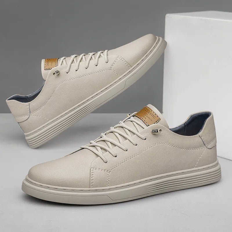 Beigefarbene Herren-Sneaker mit Schnürung, flacher Sohle mit gerippter Seitenkante und dezenten Ziernähten.