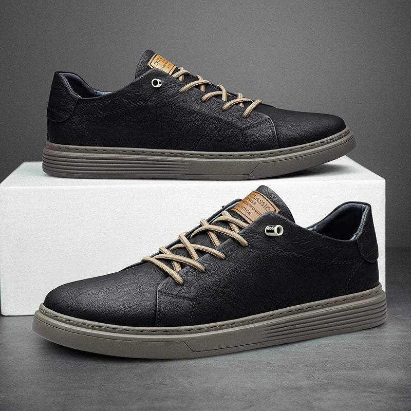 Schwarze Herren-Sneaker aus strukturiertem Leder mit beigen Schnürsenkeln und gerippter, flacher Sohle auf einem weißen Block.
