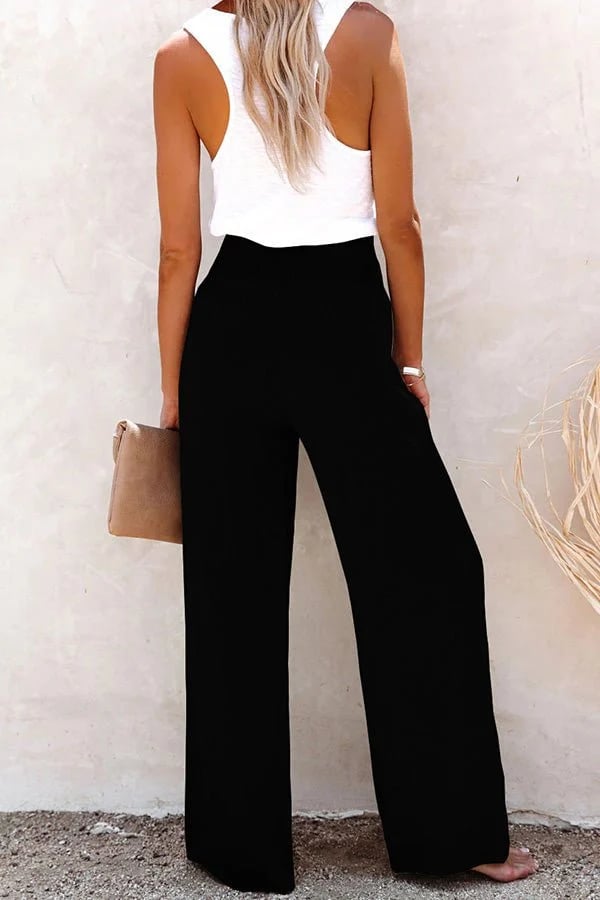 Schwarze High-Waist-Hose mit weitem Bein und gesmoktem Bund, kombiniert mit einem weißen Top für einen eleganten Sommerlook.