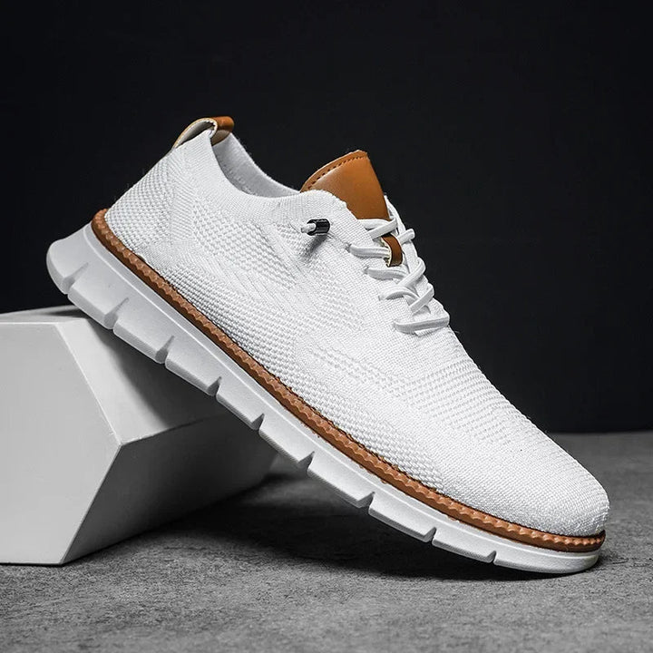 Weisser Herren-Mesh-Sneaker mit Schnürung, braunen Lederdetails und flexibler weisser Laufsohle im sportlichen Design.