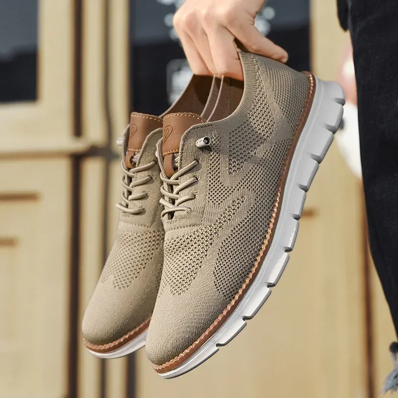Beigefarbener Herren-Mesh-Sneaker mit braunen Lederdetails, Schnürung und flexibler weißer Laufsohle.