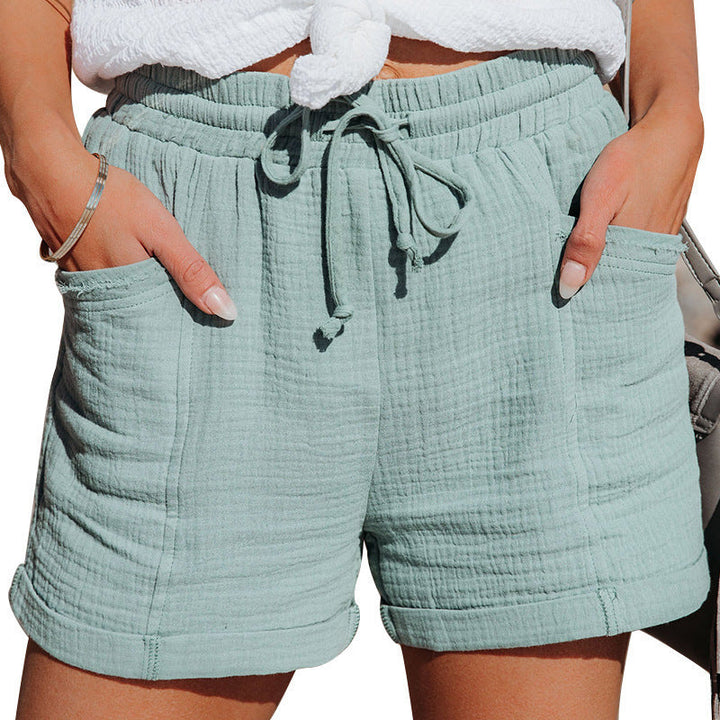 Hellgrüne Damen-Shorts aus strukturiertem Stoff mit elastischem Kordelzugbund, Seitentaschen und umgeschlagenen Säumen.