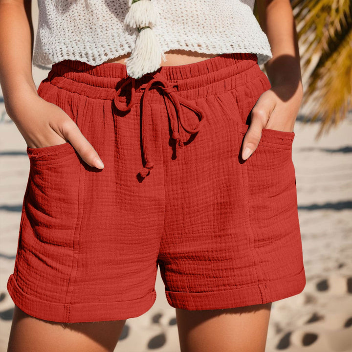 Rote Damen-Shorts aus strukturiertem Stoff mit elastischem Kordelzugbund, Seitentaschen und umgeschlagenen Säumen.