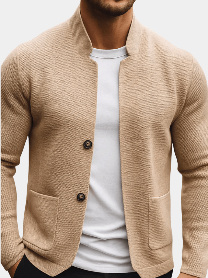 Beigefarbene Herren-Strickweste mit Stehkragen, Knopfleiste und aufgesetzten Taschen in strukturierter Optik.