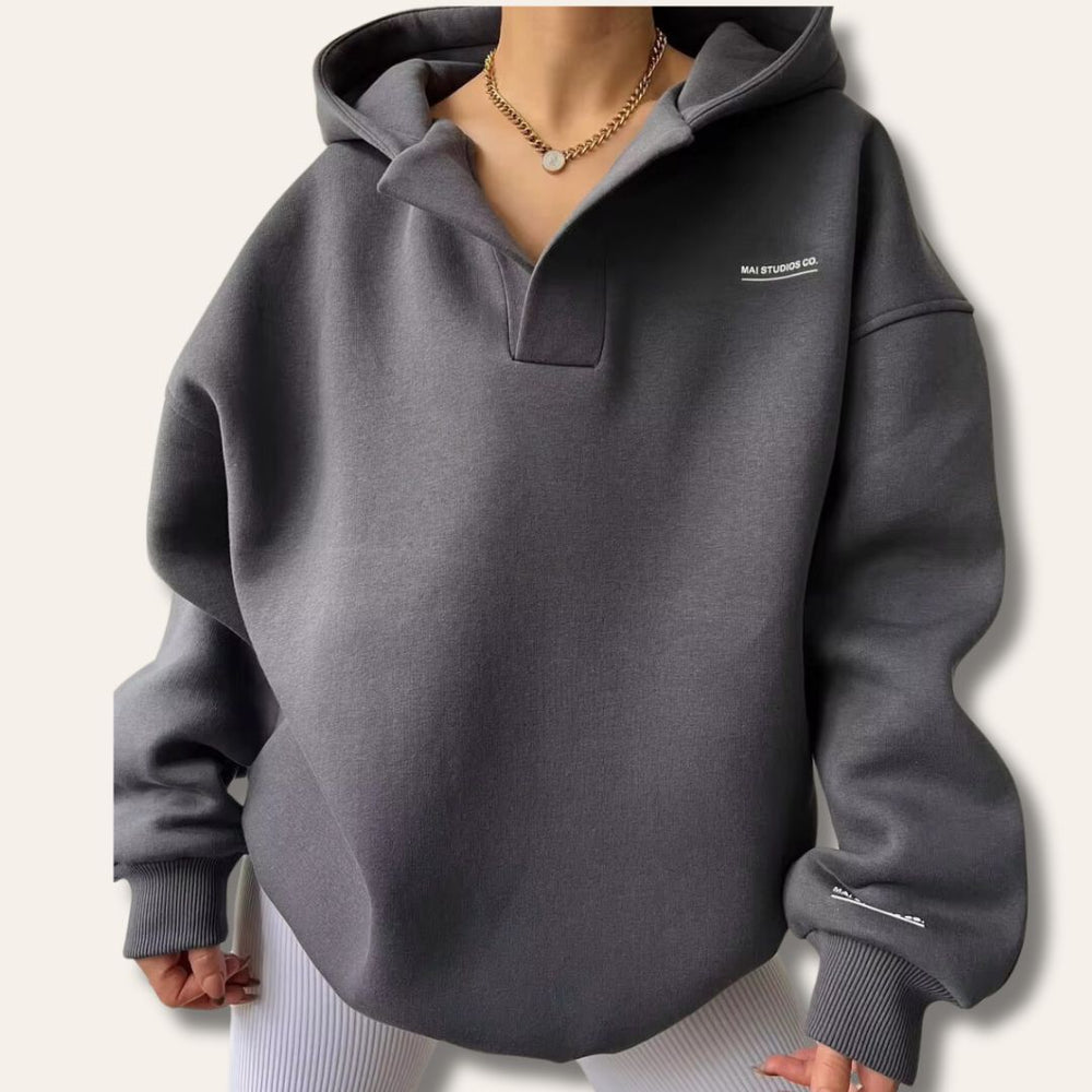 Dunkelgrauer Oversized-Hoodie mit V-Ausschnitt, überschnittenen Schultern und dezentem Brust-Print.