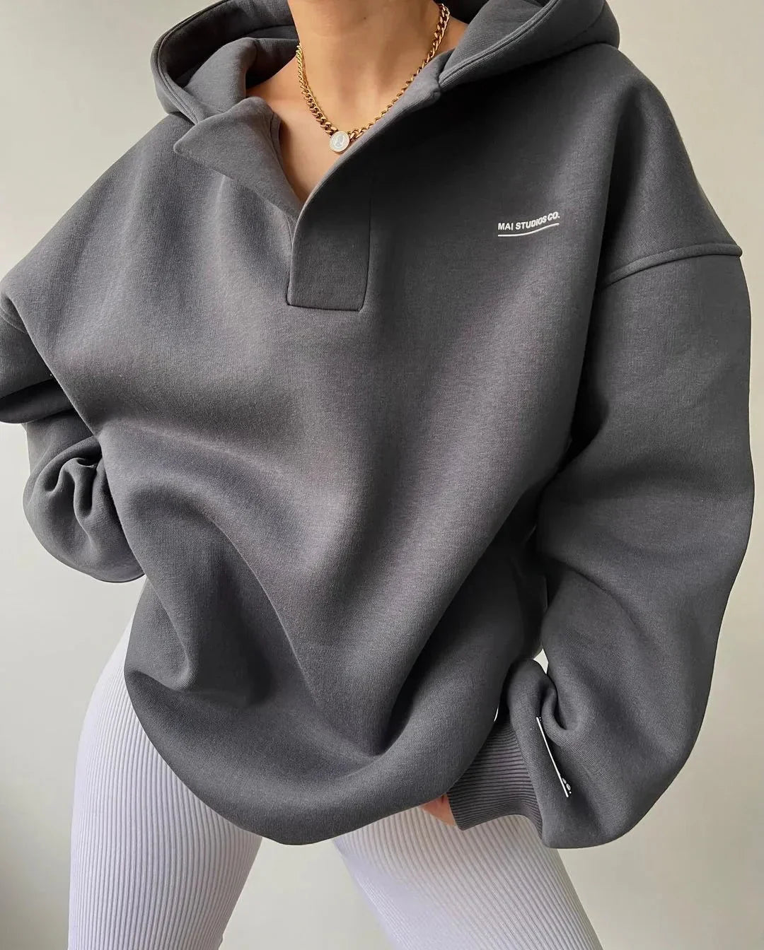 Dunkelgrauer Oversized-Hoodie mit V-Ausschnitt, Drop-Shoulder-Schnitt und dezentem Brust-Print.