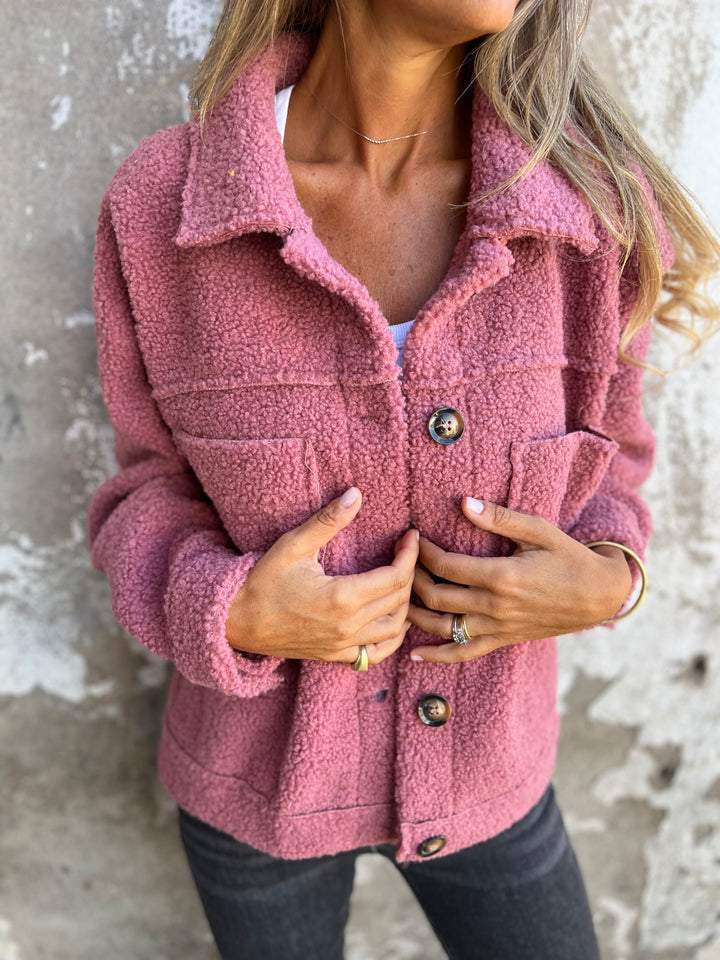 Rosa Teddyjacke für Damen mit Umlegekragen, Knopfleiste und zwei Brusttaschen aus flauschigem Material.