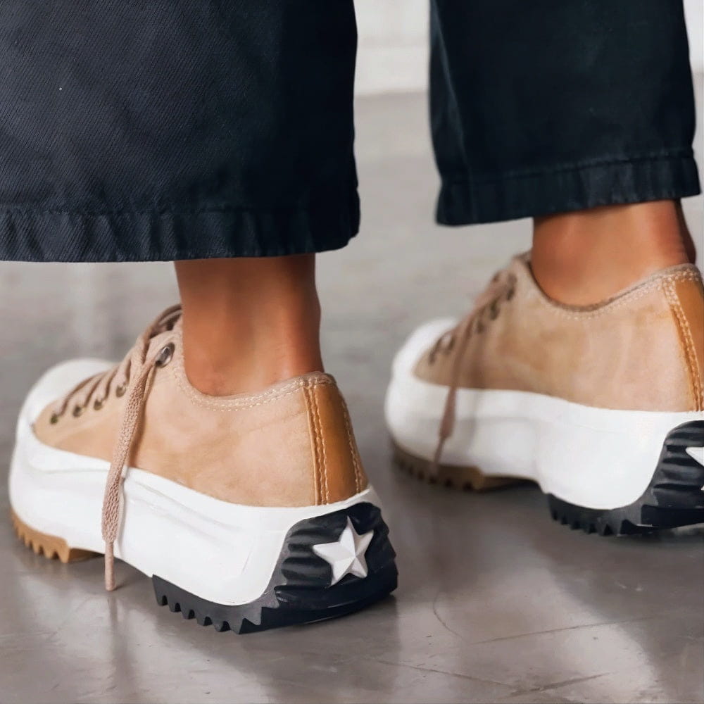 Beige Plateau-Sneaker mit Schnürung, weißer Plateausohle und markanter, gezackter Laufsohle mit Stern-Detail an der Ferse.