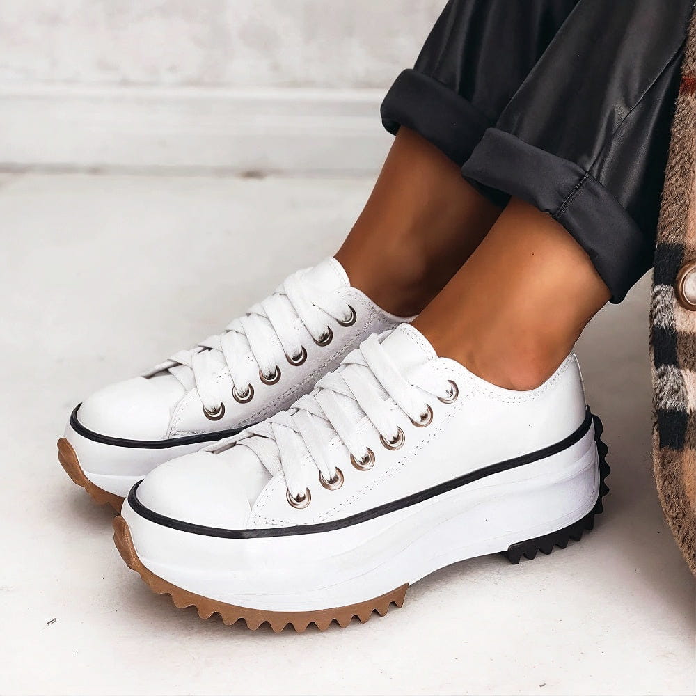 Weiße Damen-Plateau-Sneaker mit Schnürung, markanter gezackter Laufsohle und kontrastierender Zehenkappe.