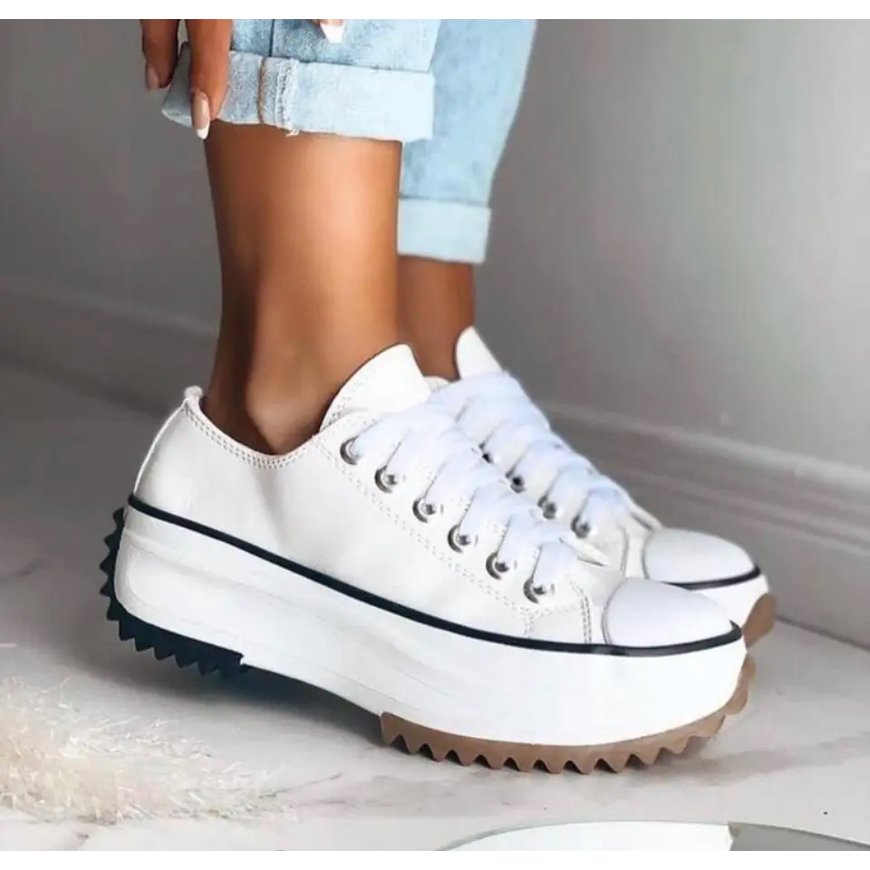Weiße Damen-Plateausneaker mit Schnürung, markanter gezackter Laufsohle und kontrastierender Zehenkappe.