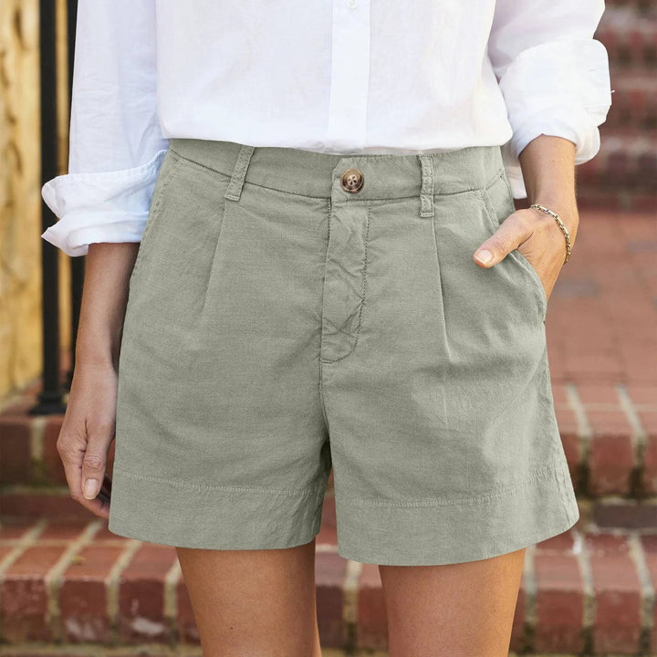 Lea Damen Kurze Hose in Salbeigrün mit Bundfalten, Seitentaschen und Knopfverschluss.