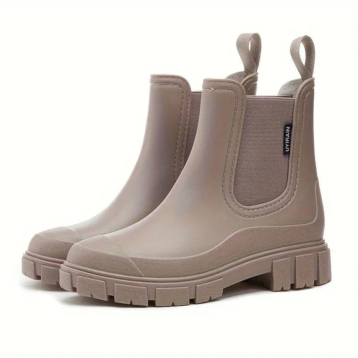 Beigefarbene, wasserdichte Damen Chelsea Boots mit elastischen Seiteneinsätzen und robuster Profilsohle auf weißem Grund.