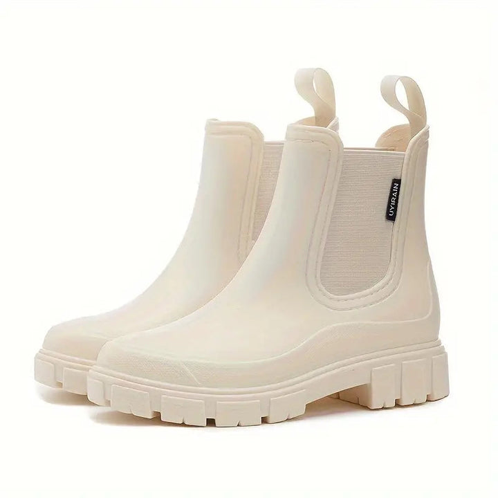 Beige wasserdichte Chelsea Boots mit Slip-On-Design, elastischen Einsätzen und robuster Profilsohle auf weißem Hintergrund.