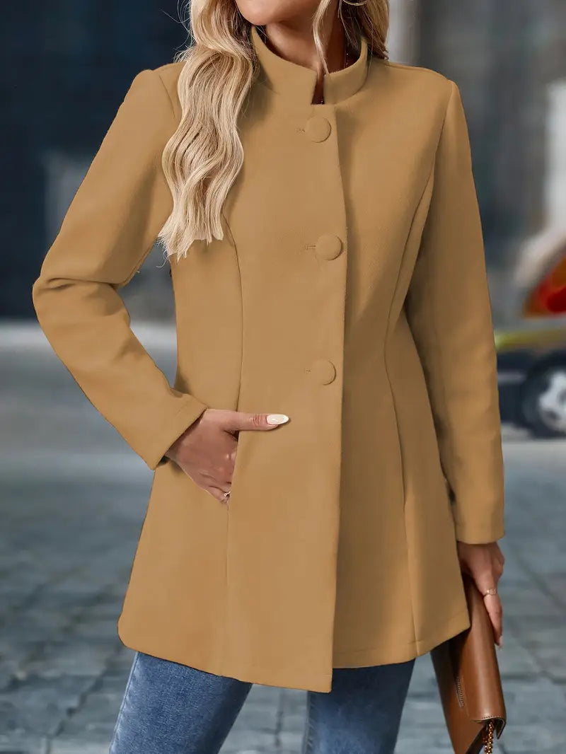 Taillierter beigefarbener Damenmantel mit Stehkragen, Knopfleiste und praktischen Seitentaschen für einen eleganten Look.