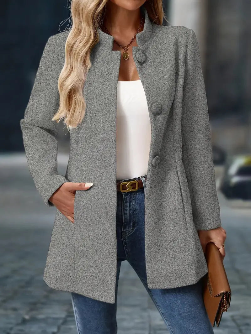 Taillierter grauer Damenmantel mit Stehkragen, Knopfleiste und Seitentaschen für einen eleganten Look.