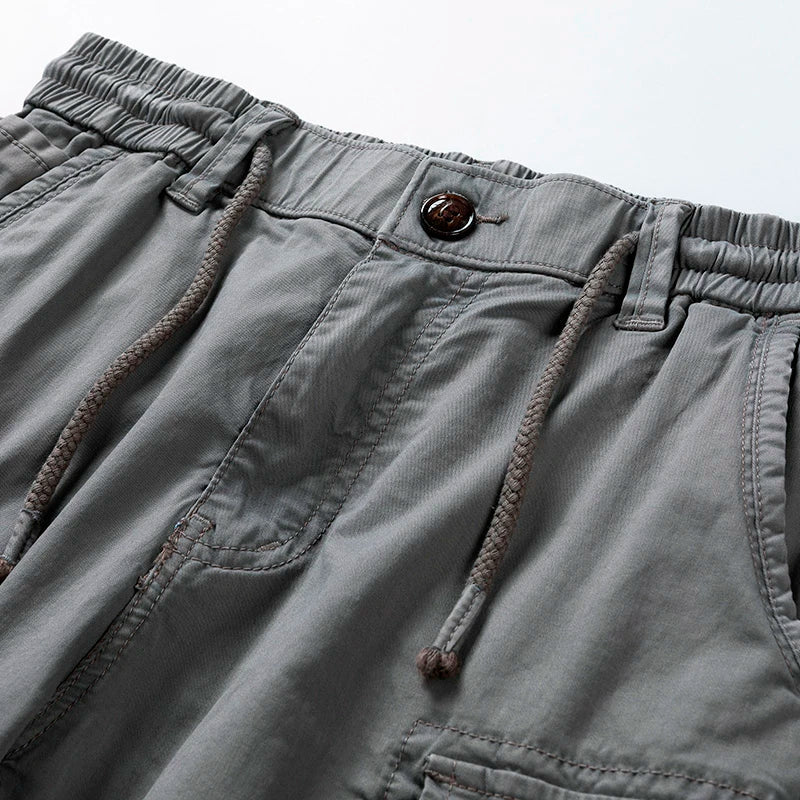 Graue Herren-Cargoshorts mit elastischem Bund, Kordelzug und Knopfverschluss im Utility-Stil.