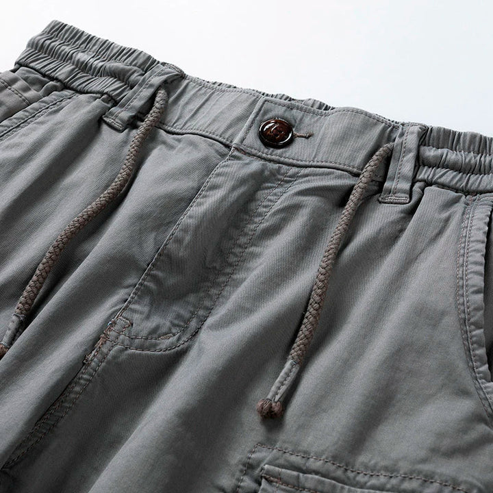 Graue Herren-Cargoshorts mit elastischem Bund, Kordelzug und Knopfverschluss im Utility-Stil.