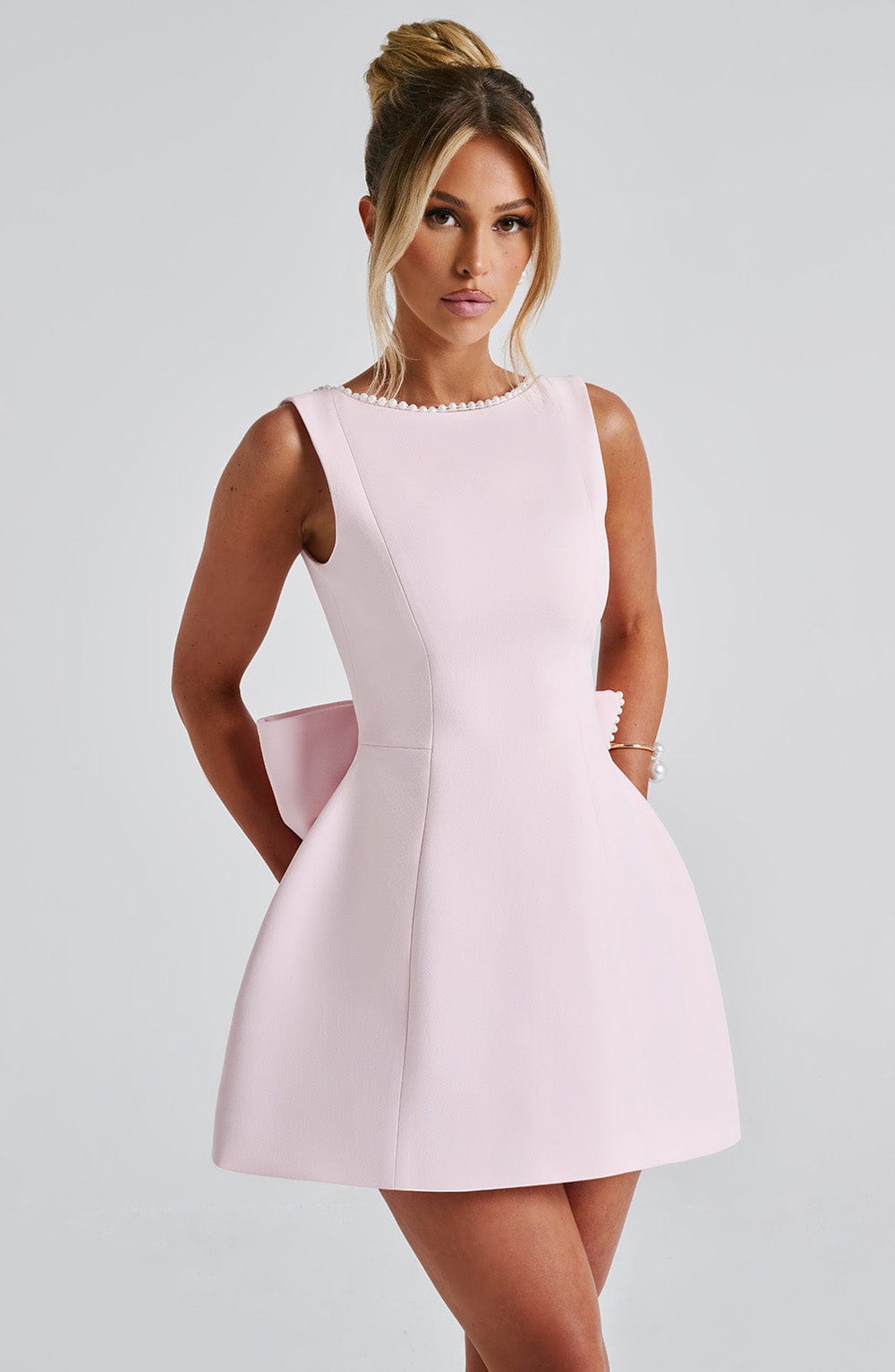 Ärmelloses Leonie Minikleid in Rosa mit Perlenverzierung am Ausschnitt und Rückenschleife.