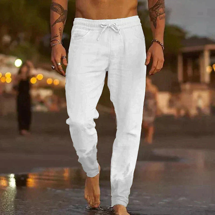 Weiße Herren-Leinenhose mit elastischem Bund, Kordelzug und lockerem Schnitt für einen entspannten Sommer-Look.