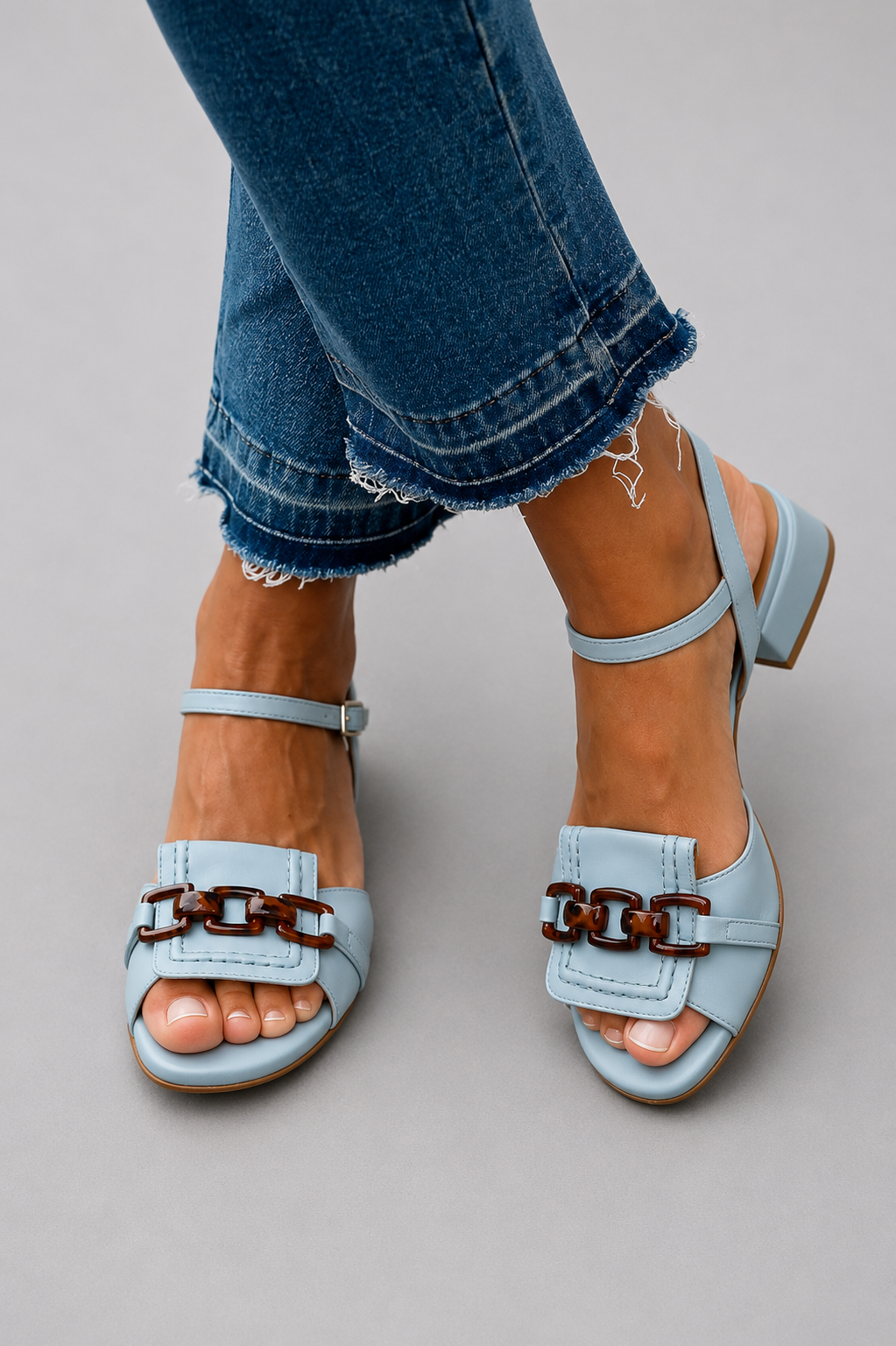 Blaue Lisa Sandaletten mit Blockabsatz und braunem Kettendetail zu Jeans.