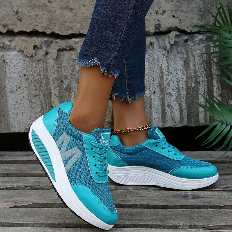Türkisblaue Damen-Plateau-Sneaker aus atmungsaktivem Mesh mit weißer Keilsohle und seitlichem Blumenmuster.