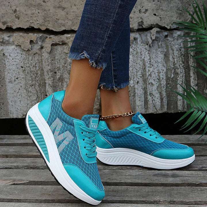 Türkisblaue Damen-Plateau-Sneaker aus atmungsaktivem Mesh mit weißer Keilsohle und seitlichem Blumenmuster.