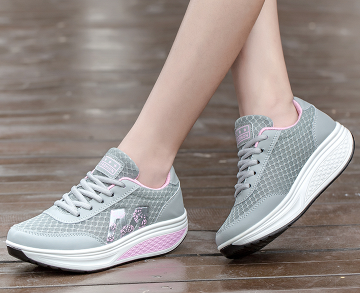 Grauer Damen-Plateau-Sneaker aus Mesh mit rosa Details, Schnürung und floralem Seitenmuster auf einer weißen Sohle.