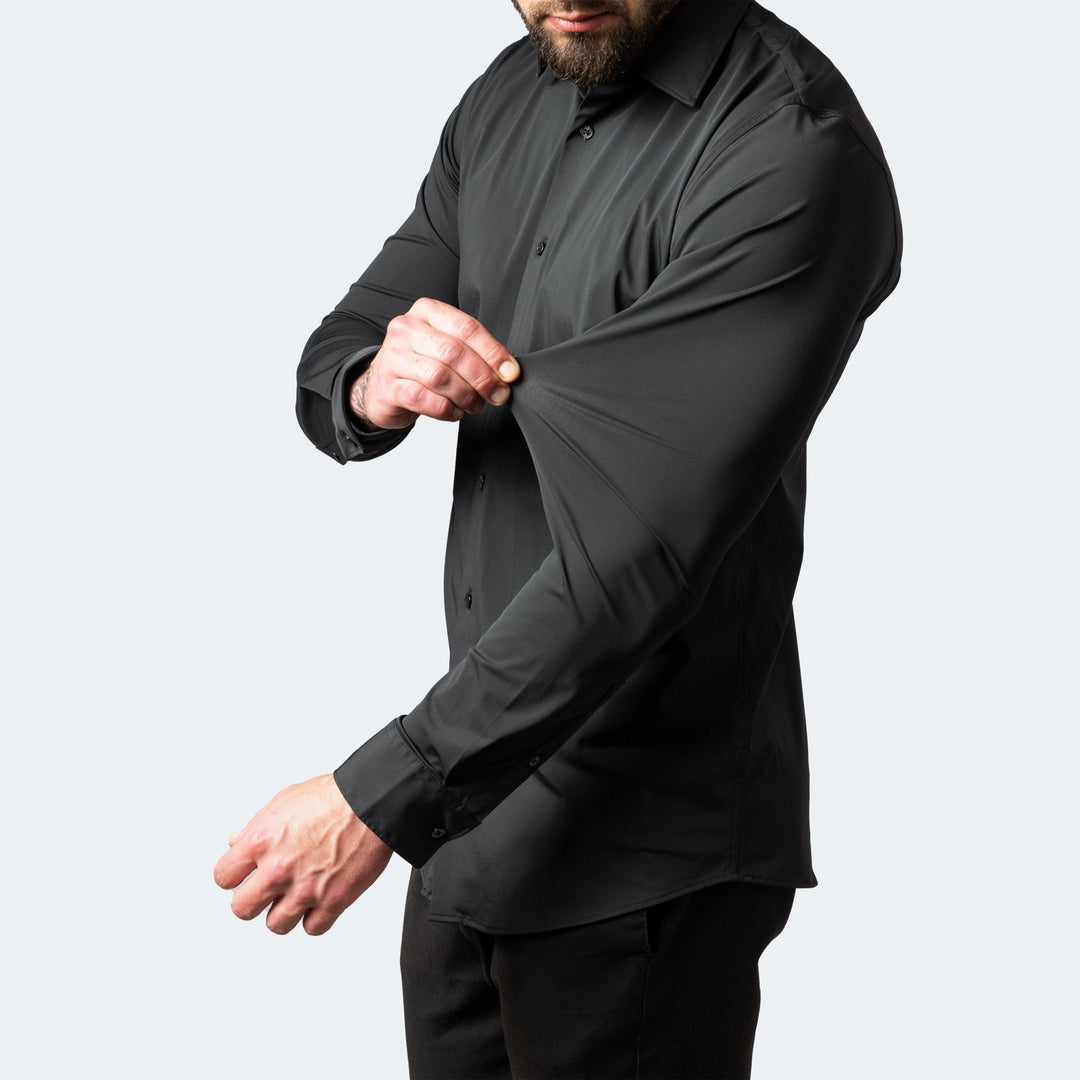 Schwarzes Slim Fit Stretch-Hemd für Herren mit langem Arm, das die Elastizität des Stoffes am Ärmel demonstriert.