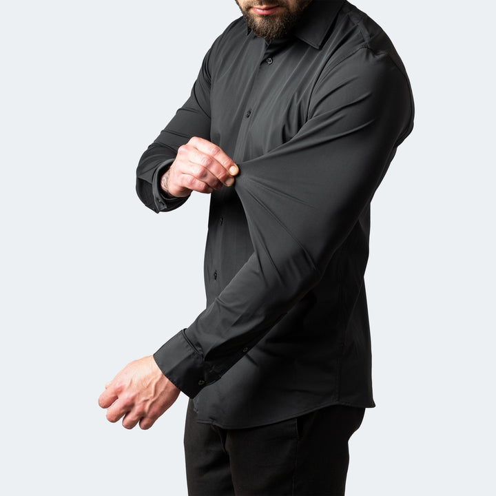 Schwarzes Slim Fit Stretch-Hemd für Herren mit langem Arm, das die Elastizität des Stoffes am Ärmel demonstriert.