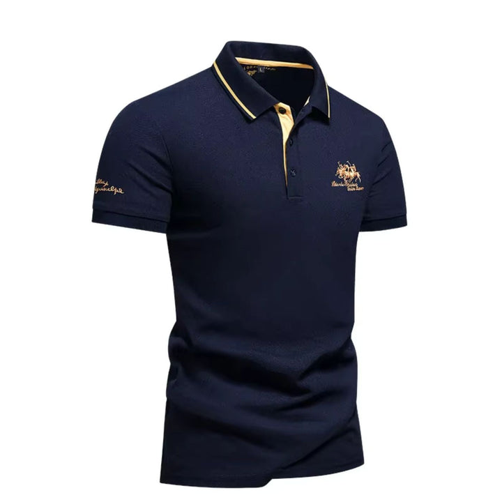 Dunkelblaues Herren-Poloshirt aus Baumwoll-Piqué mit gelben Akzenten am Kragen und goldener Stickerei auf der Brust.
