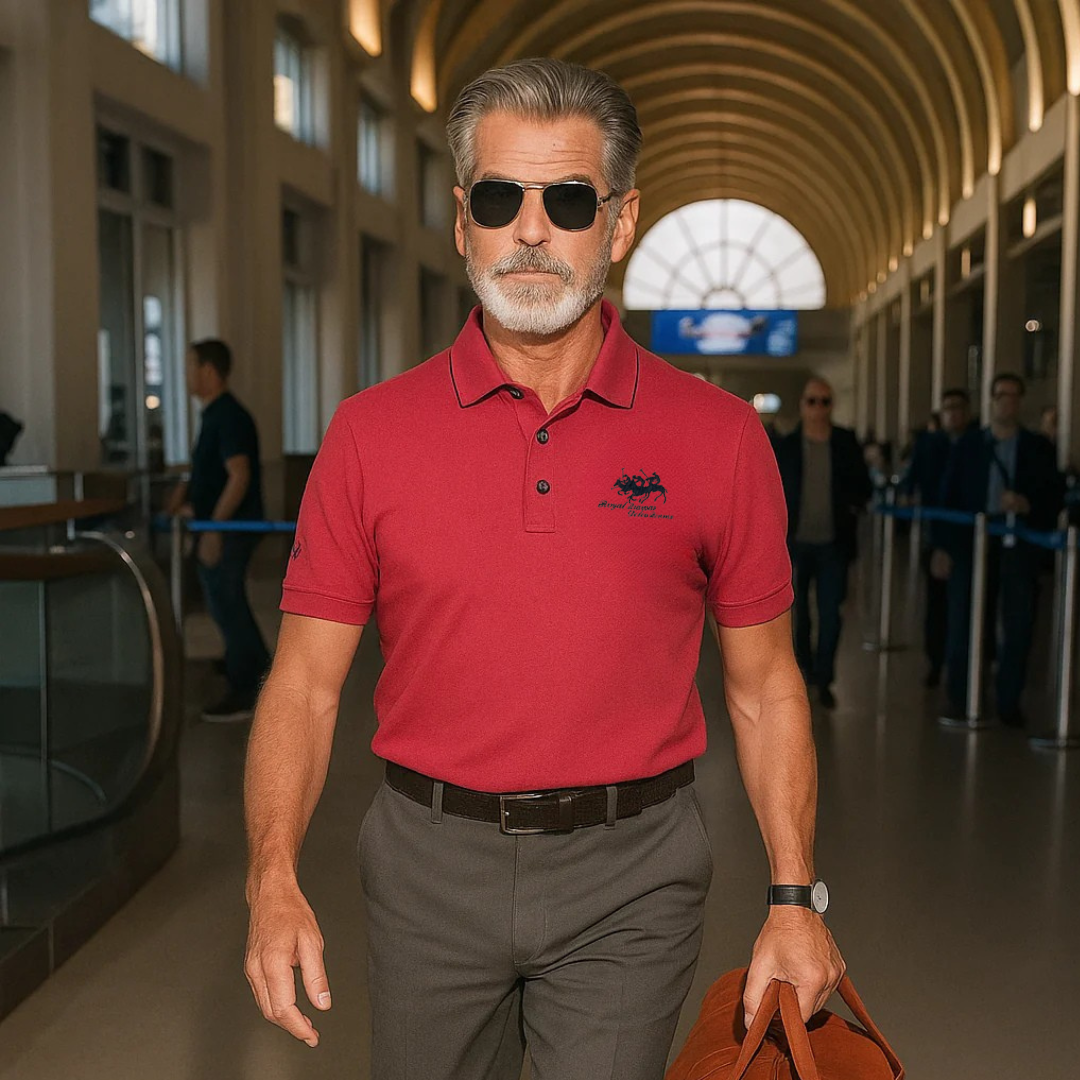 Rotes Herren-Poloshirt aus Piqué-Baumwolle mit klassischem Kragen und dezenter Stickerei, kombiniert mit grauer Hose.