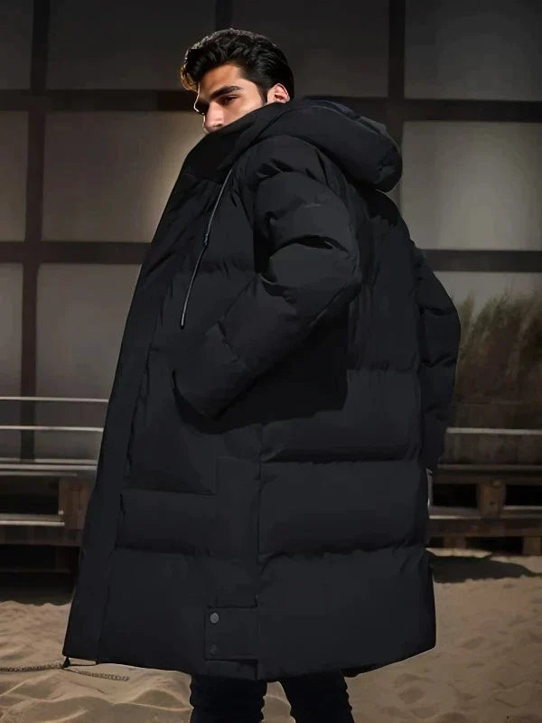 Schwarze, lange Herren-Pufferjacke mit Kapuze und dicker Wattierung für optimalen Wärmeschutz im Winter.