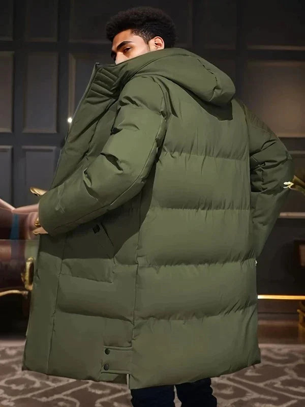 Lange, olivgrüne Lukas Pufferjacke für Herren mit Kapuze, gesteppter Wattierung und schützendem, verlängertem Schnitt.
