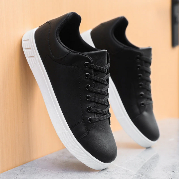 Schwarze Herren-Sneaker in Lederoptik mit klassischer Schnürung und kontrastierender weißer Sohle.