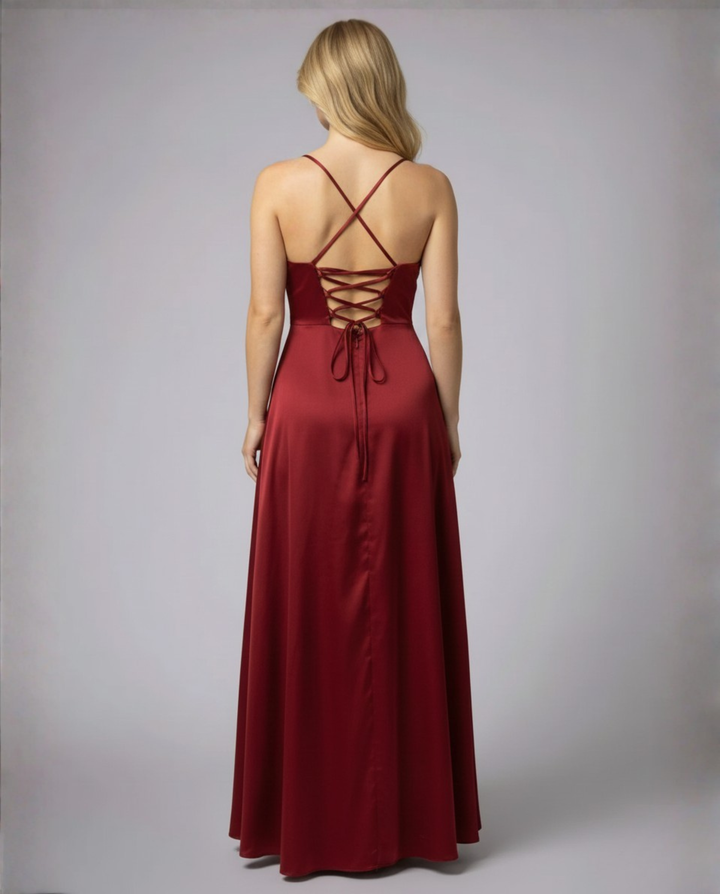 Dunkelrotes Maxikleid aus fließendem Satin mit Rückenschnürung und schmalen Trägern vor grauem Hintergrund.
