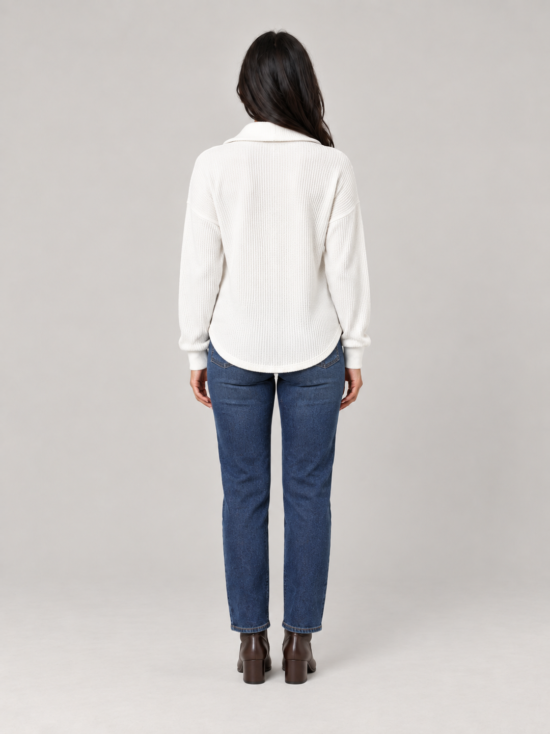 Weißer Damen-Troyer in Waffelstrick mit Stehkragen und lockerer Passform, kombiniert mit blauer Jeans.